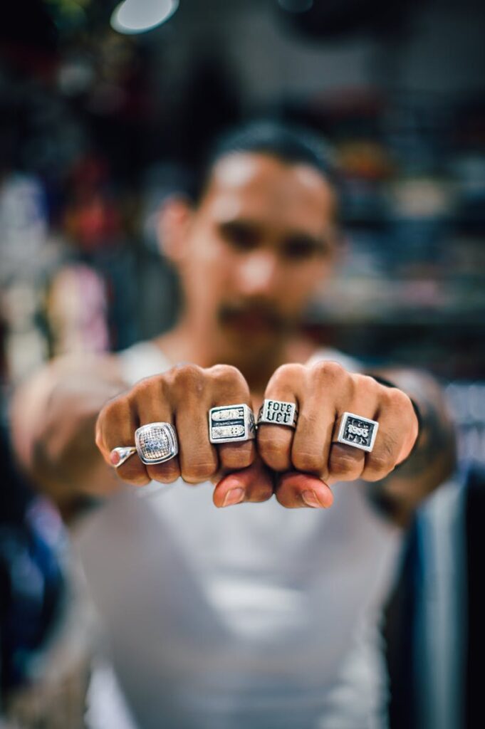 Young man displaying rings on his fingers with selective focus.